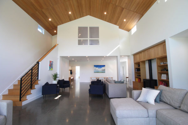 Open concept living space in a modern farmhouse with a polished, concrete floor